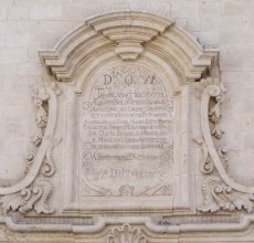 Iscrizione per la riedificazione della chiesa avvenuta nel 1764, posta sul portale principale